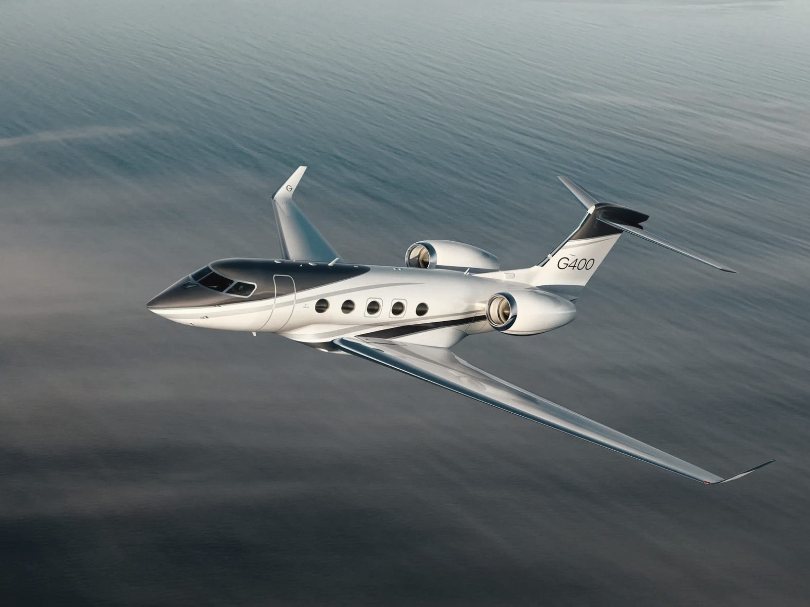 A Gulfstream business jet in flight above open ocean