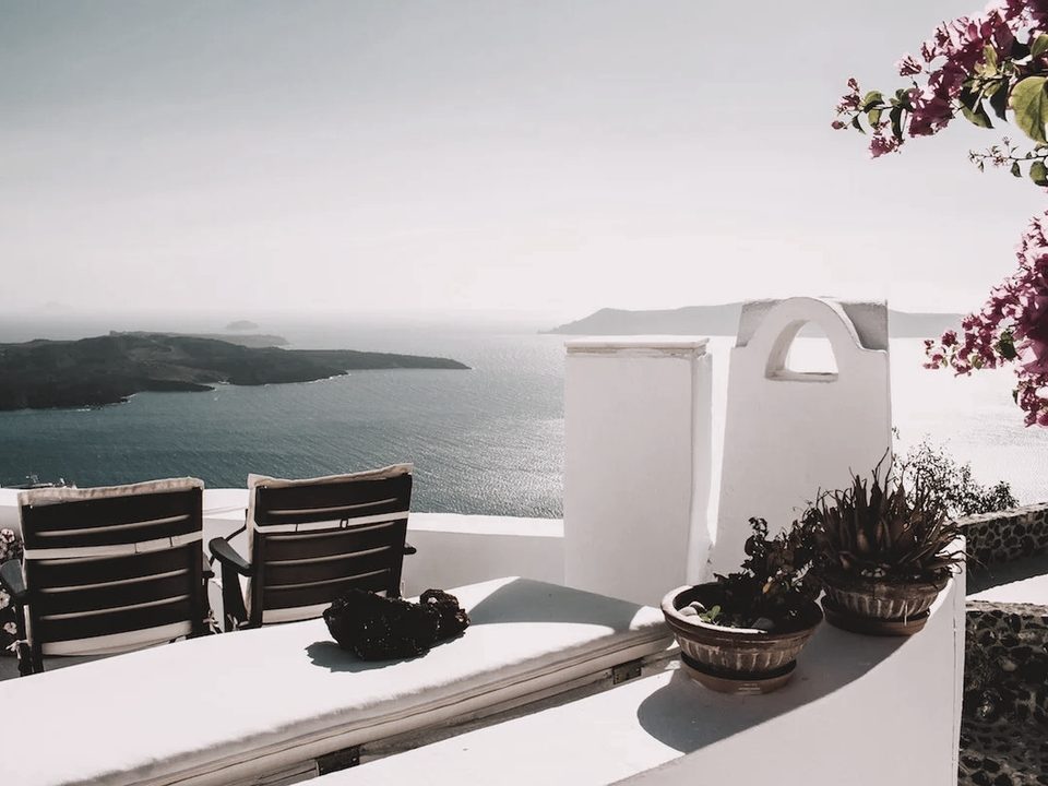 A whitewashed terrace above the sea, bougainvillea in flower